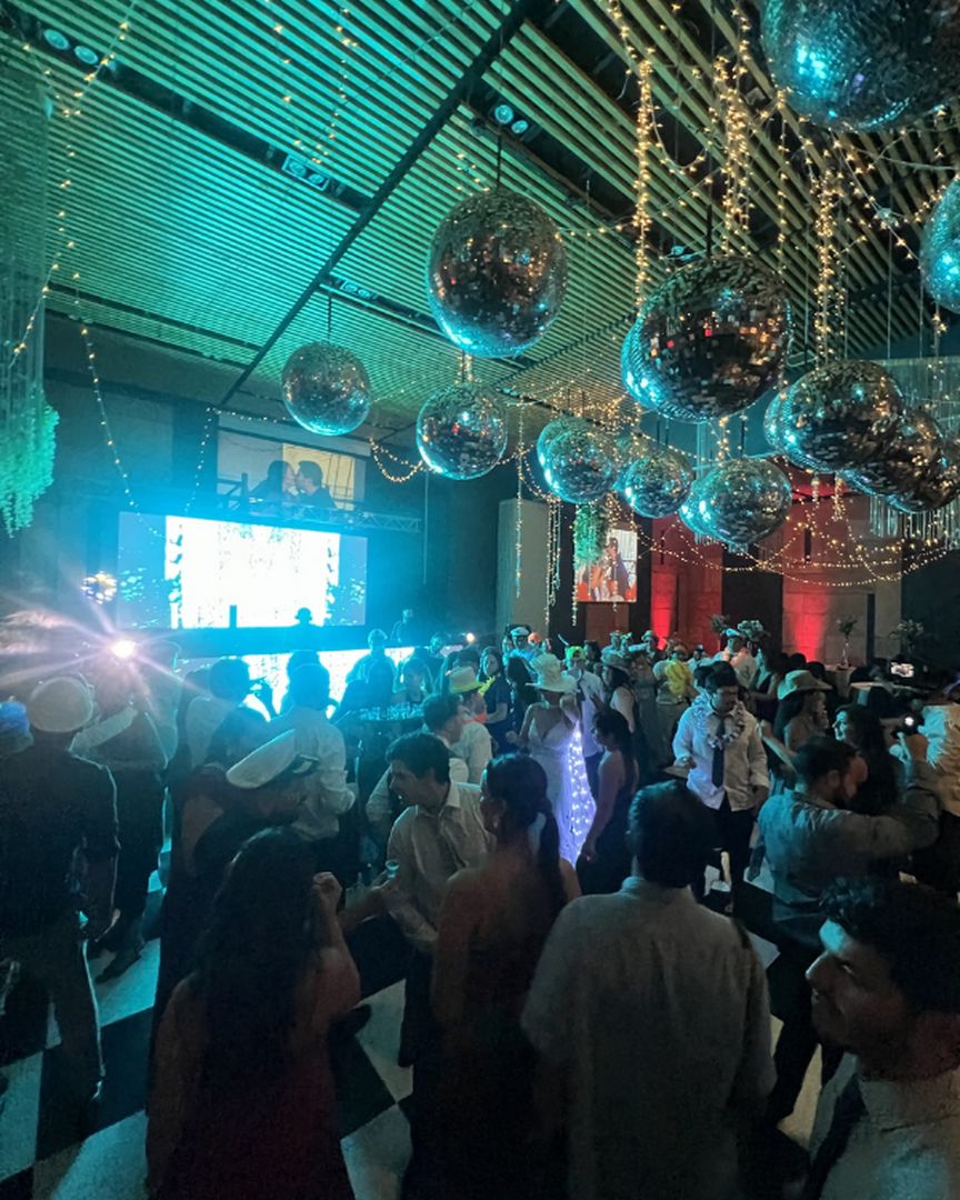 Fiesta bajo bolas disco y luz turquesa · AO Producción